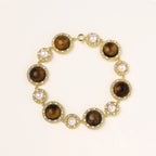 Gold-plated link bracelet with alternating brown tiger's eye stones and white freshwater pearls in ornate bezels.