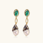 Gold drop earrings with iridescent abalone studs, rope links, jeweled caps and white baroque pearls on cream background