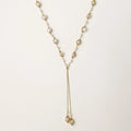 Adjustable gold lariat necklace with freshwater pearls nested in delicate cage settings and Y-shaped tassel drop