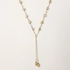 Adjustable gold lariat necklace with freshwater pearls nested in delicate cage settings and Y-shaped tassel drop