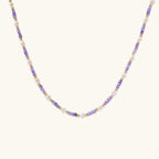Delicate 18K gold vermeil necklace with alternating lavender zirconia beads and white freshwater pearls on cream background
