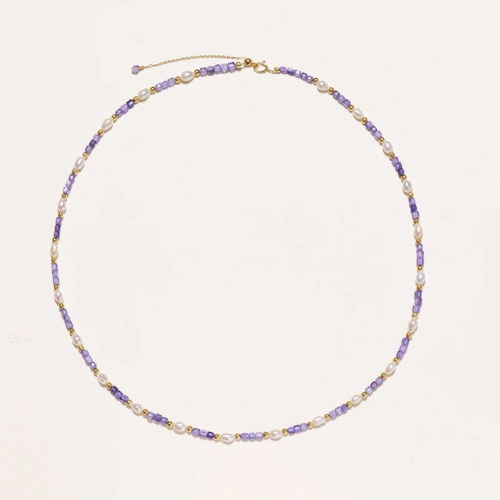 Delicate 18K gold vermeil necklace with alternating lavender zirconia beads and white freshwater pearls on cream background