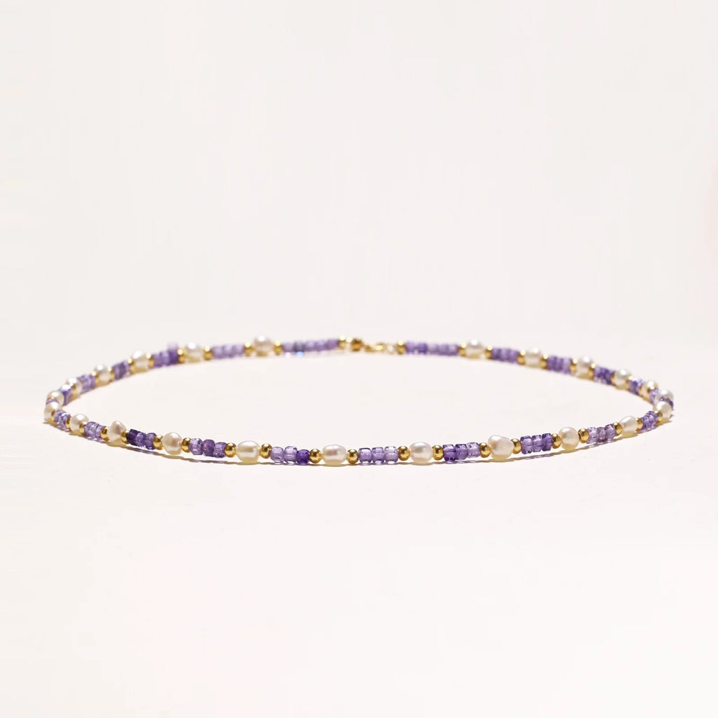 Delicate 18K gold vermeil necklace with alternating lavender zirconia beads and white freshwater pearls on cream background