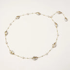 Long gold chain necklace with baroque pearls wrapped in leaf designs and small freshwater pearls spaced along the strand