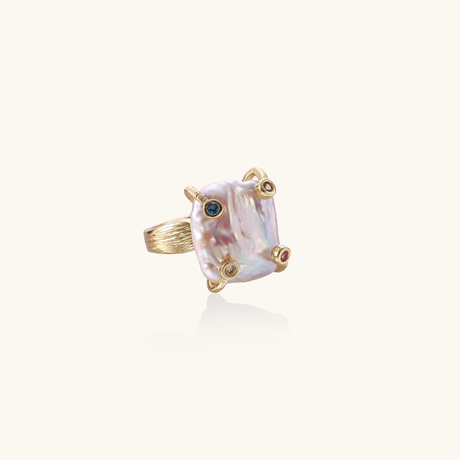 Gold ring with large iridescent baroque pearl and four colored gemstones on textured band