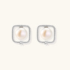 Rhodium-plated silver stud earrings with cushion frame, centered freshwater pearl, and tiny crystal accent