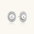 Oval rhodium-plated silver studs featuring freshwater pearls surrounded by pavé crystal halo on white background