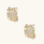 Gold-plated sculptural hoop earrings with geometric lattice centerband and sparkling zirconia on white background.