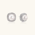 Cushion-shaped sterling silver stud earrings with freshwater pearls surrounded by geometric diamond halos