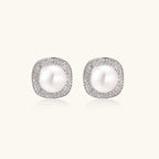 Cushion-shaped sterling silver stud earrings with freshwater pearls surrounded by geometric diamond halos