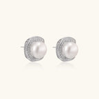 Cushion-shaped sterling silver stud earrings with freshwater pearls surrounded by geometric diamond halos