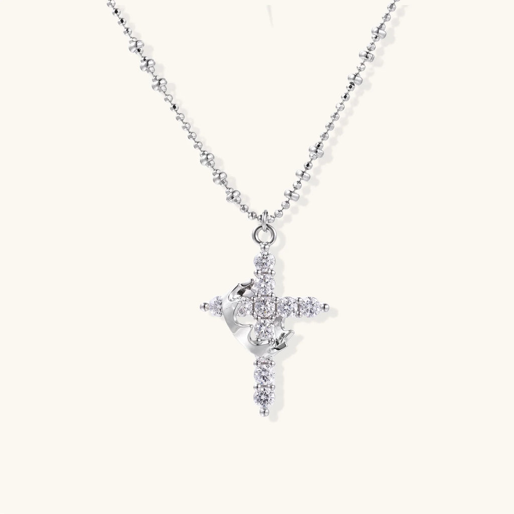 White gold-plated cross pendant adorned with sparkling zirconia stones and crescent moon accent on ball chain