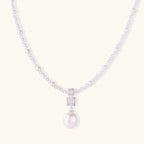 Dainty necklace with lavender crystal beads, freshwater pearls, geometric pendant, and large pearl drop on white background.