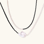 Double-strand necklace with black faceted quartz and white pearls featuring an oversized baroque pearl centerpiece