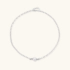 Dainty rhodium-plated silver chain necklace with centered 10mm freshwater pearl and crystal accents on cream background