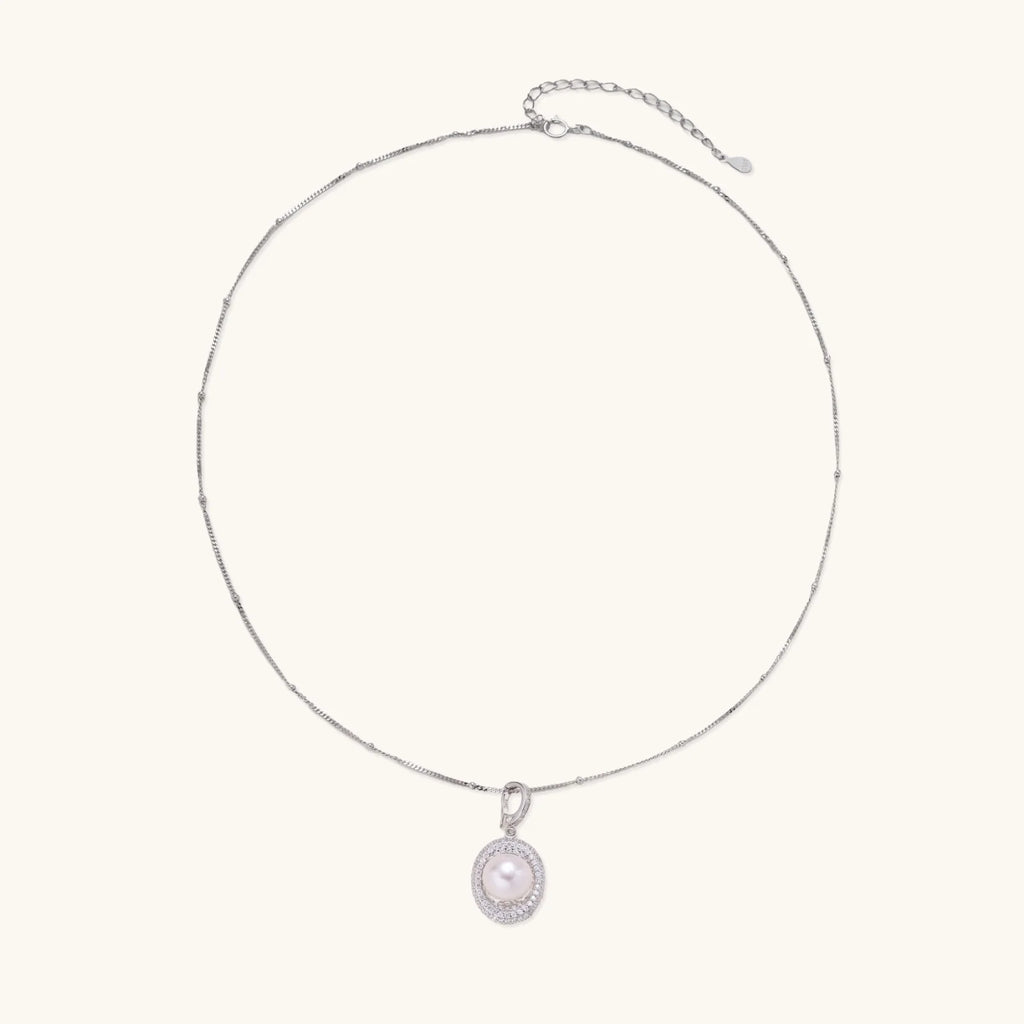 Oval sterling silver pendant with crystal halo surrounding a white freshwater pearl on delicate chain