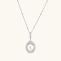 Oval sterling silver pendant with crystal halo surrounding a white freshwater pearl on delicate chain