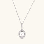 Oval sterling silver pendant with crystal halo surrounding a white freshwater pearl on delicate chain