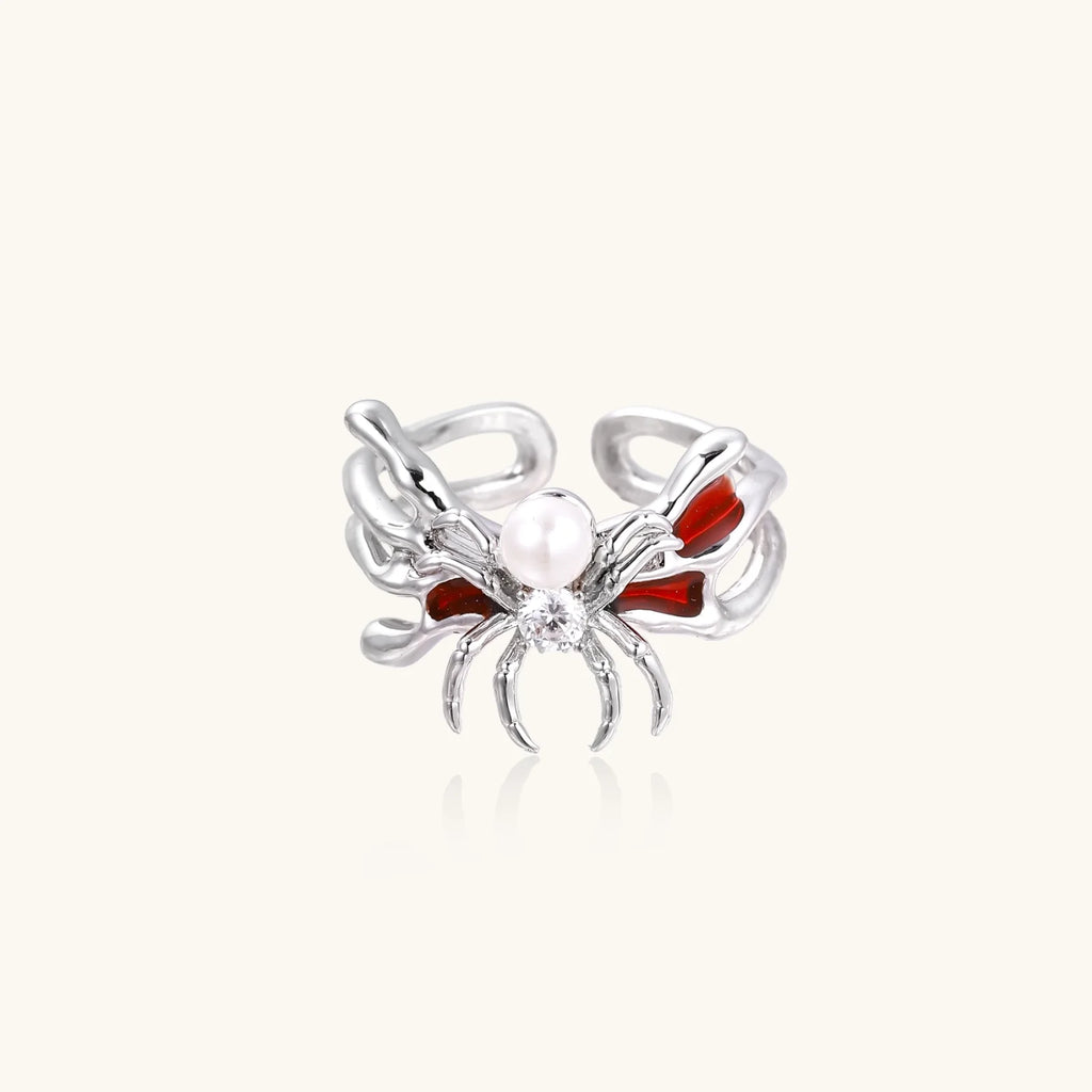 White gold plated spider ring with pearl body, clear zirconia center, and red enamel leg accents on adjustable band