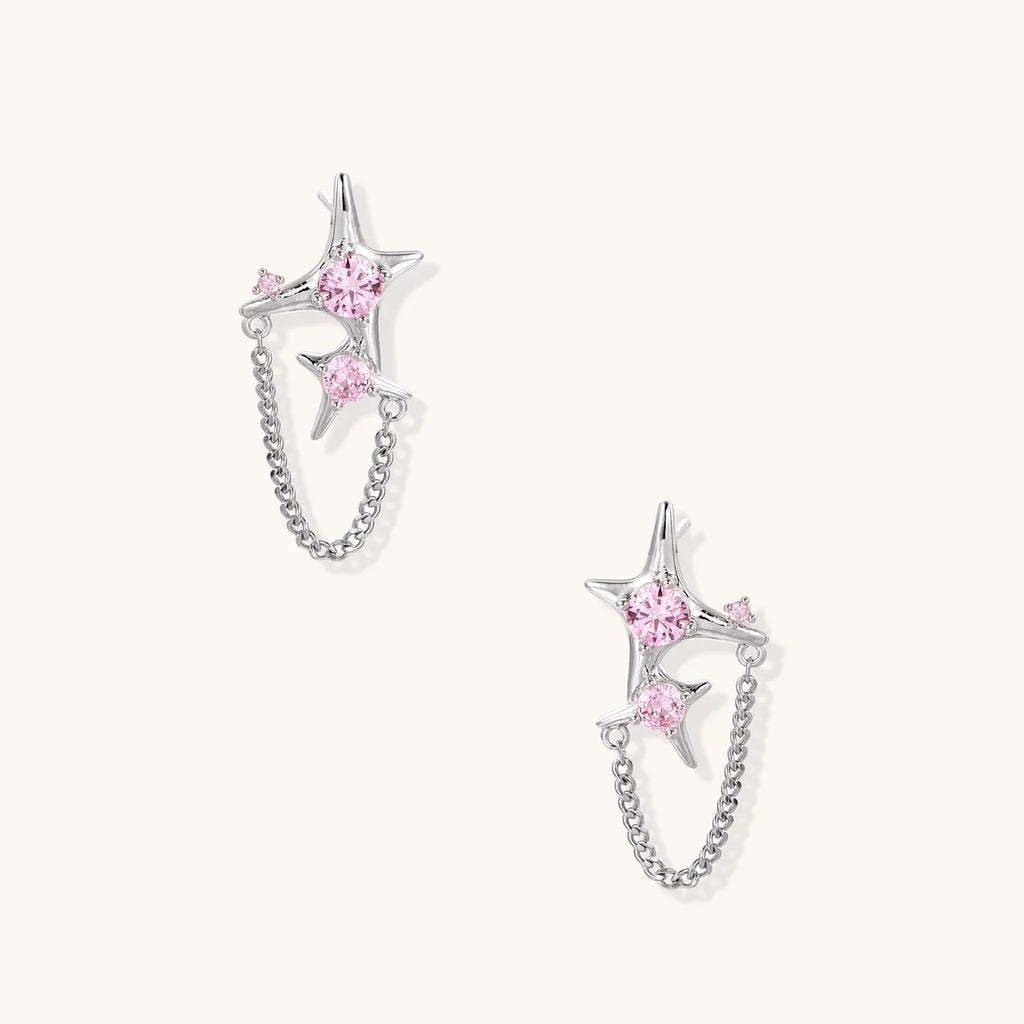 Pair of silver star-shaped ear climbers with pink zirconia stones connected by delicate chains