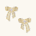 Filigree bow-shaped earrings with marquise center stone and lattice ribbon tails in gold and silver finishes