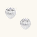 White gold-plated shell-textured stud earrings with three zirconia crystals on ridged surface against cream background.