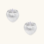 White gold-plated shell-textured stud earrings with three zirconia crystals on ridged surface against cream background.