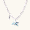 Pearl necklace with playful blue dog pendant accented with sparkly crystals on cream background.