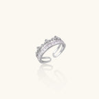 Silver-toned adjustable crown ring with channel-set square zirconia stones and delicate floral details on white background