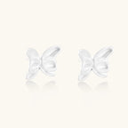 Pair of translucent butterfly-shaped stud earrings with frosted finish and dimensional wing details on white background