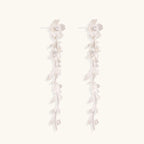 Long sterling silver drop earrings with delicate floral vine design and crystal accents on white background