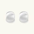 Brushed sterling silver cushion-shaped stud earrings with matte finish on white background