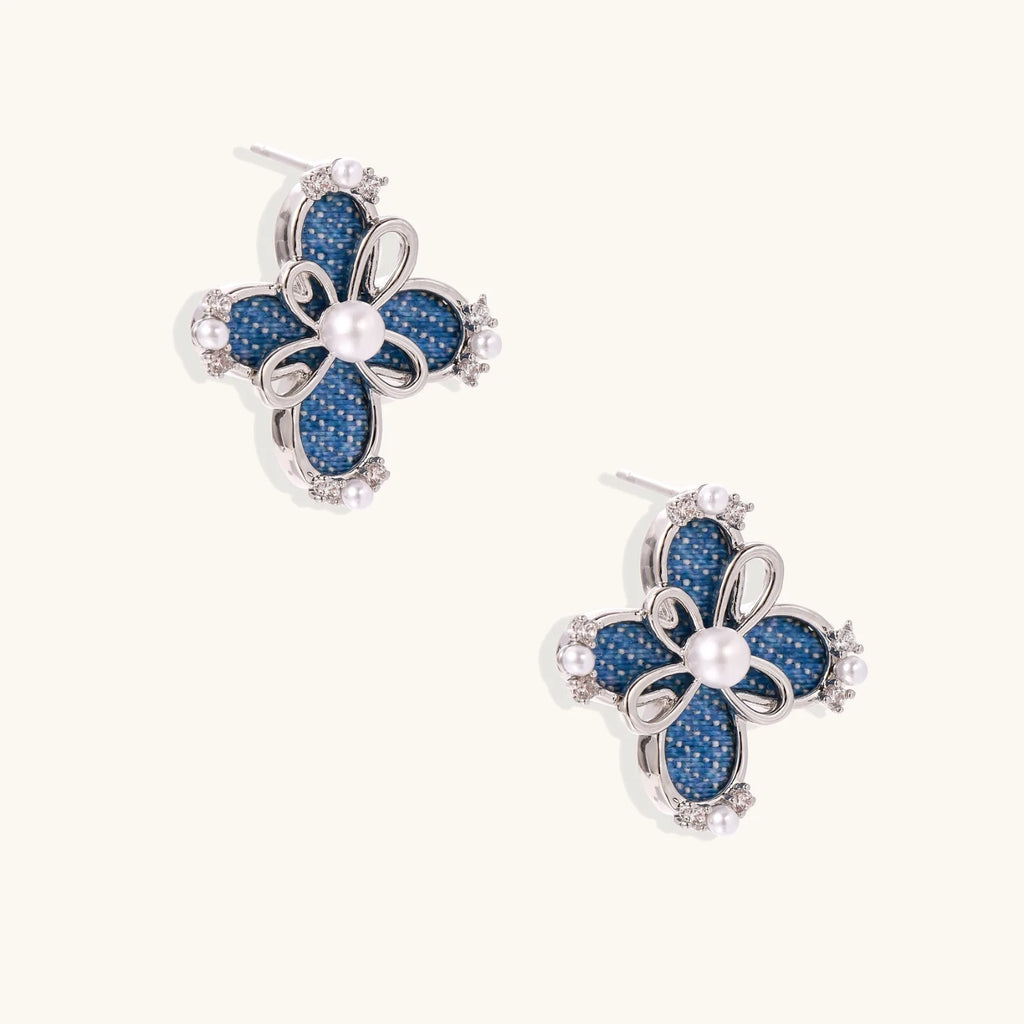 Blue denim fabric flower studs with white gold plated petals, pearl center, and zirconia accents on white background
