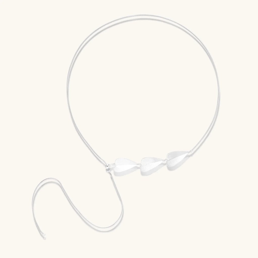 Minimalist sterling silver necklace with three brushed leaf-shaped pendants on delicate chain against white background