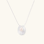 Sterling silver disc necklace with textured finish and centered freshwater pearl on delicate chain