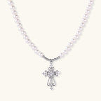 White pearl beaded necklace with ornate crystal-embellished cross pendant on white background, white gold plated finish