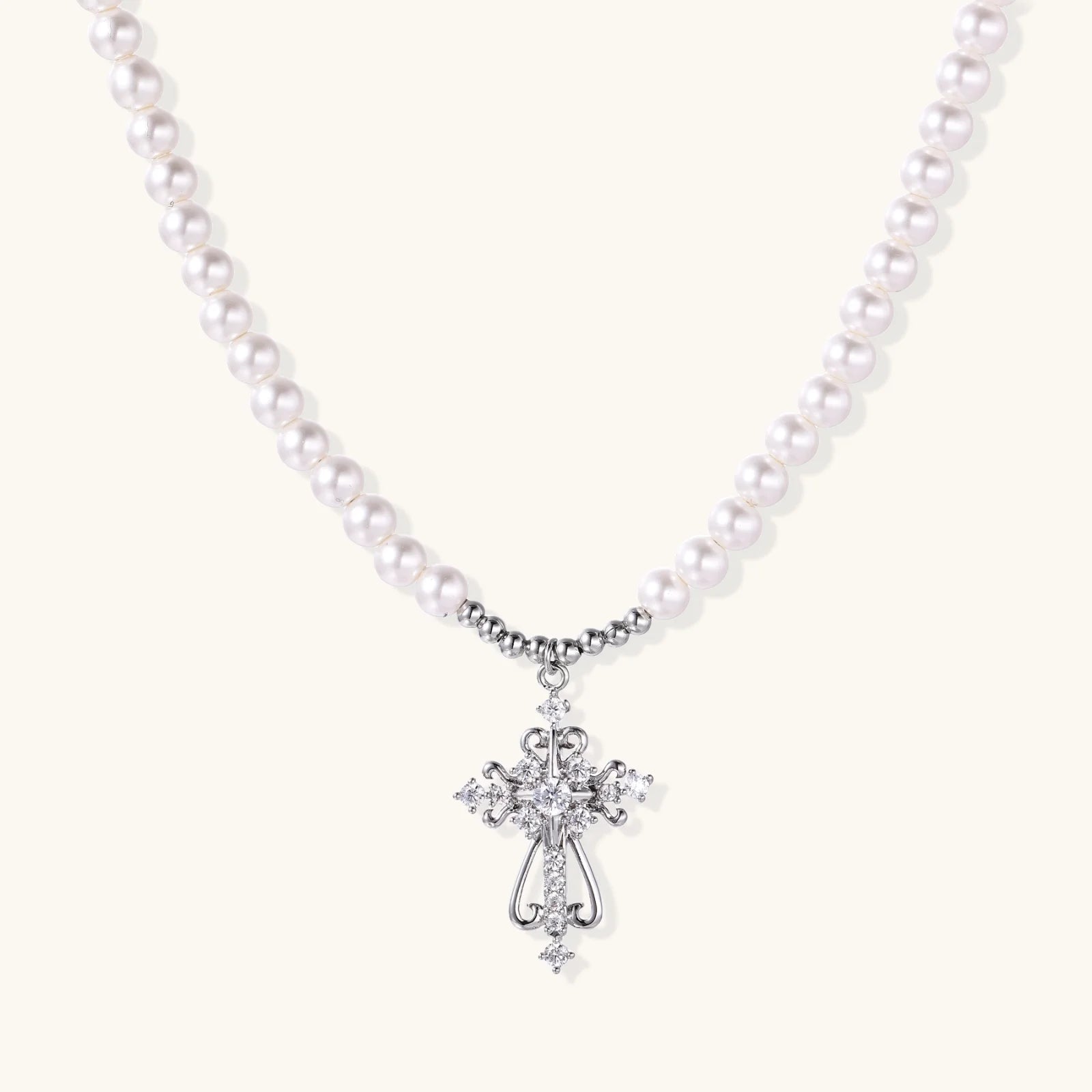 White pearl beaded necklace with ornate crystal-embellished cross pendant on white background, white gold plated finish