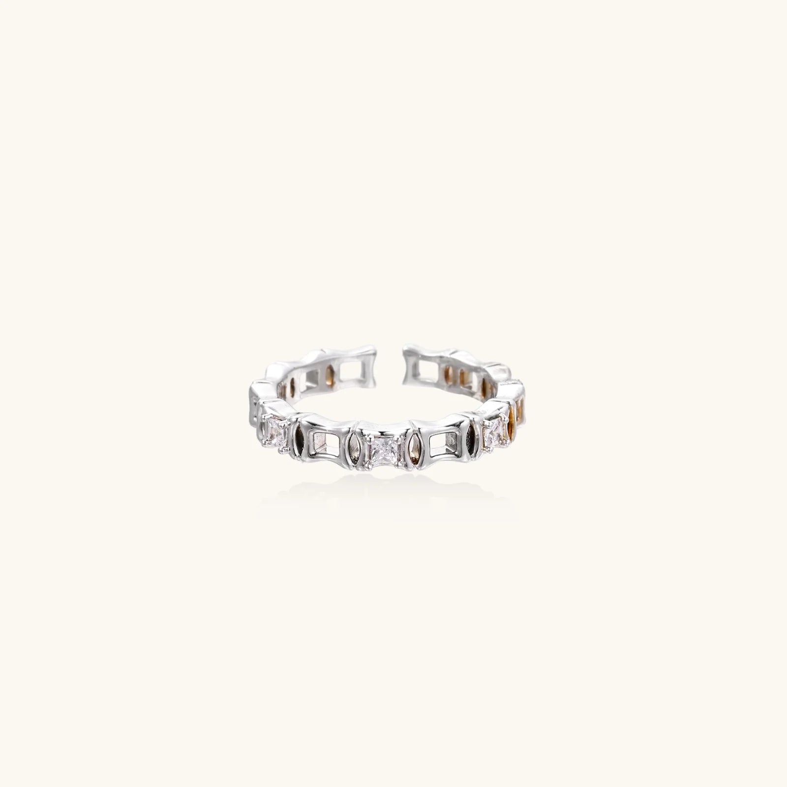 White gold plated ring with architectural lattice design and zirconia accents on cream background