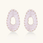 Oval lavender enamel earrings with marbled finish and gold-plated beaded border on cream background.