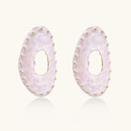 Oval lavender enamel earrings with marbled finish and gold-plated beaded border on cream background.