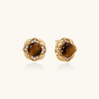 Gold-plated stud earrings with ornate floral frames surrounding cabochon tiger's eye stones and zirconia accents