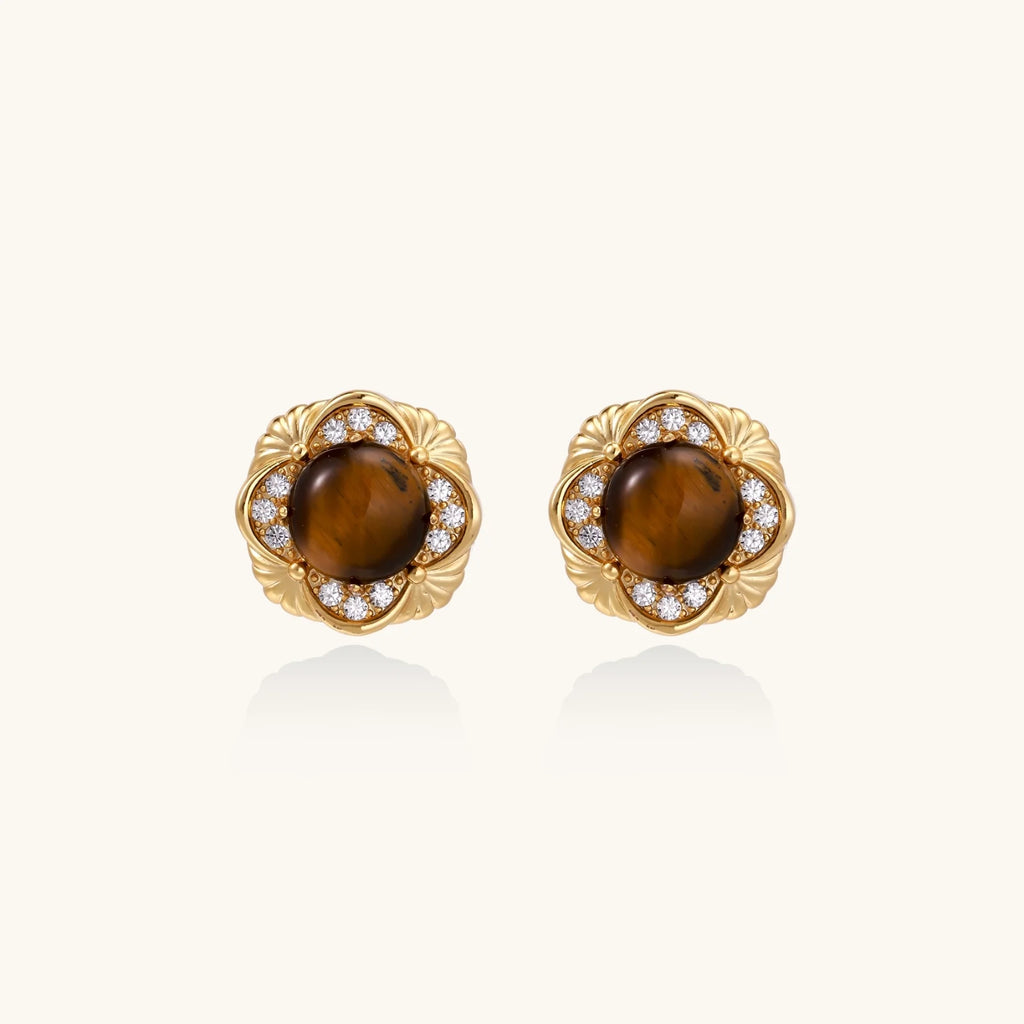 Gold-plated stud earrings with ornate floral frames surrounding cabochon tiger's eye stones and zirconia accents
