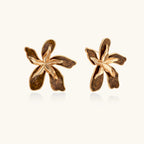 Gold-plated brass flower earrings with brown tortoiseshell enamel petals on cream background