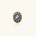 Gold-plated ring with oval blue floral cameo, pearl accents, and black enamel detailing on white background.