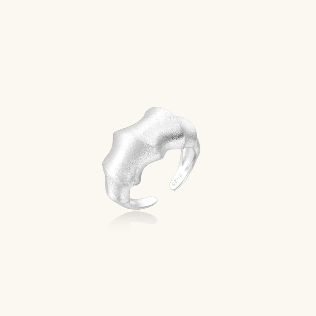 Brushed sterling silver ring with organic wave-like edges and adjustable cuff design on white background