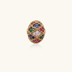 Oversized gold ring with geometric mosaic pattern featuring multicolor zirconia stones in ruby, emerald, sapphire, and clear tones.