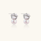 White gold stud earrings with square crystal stones in twisted frames and pink freshwater pearl drops below