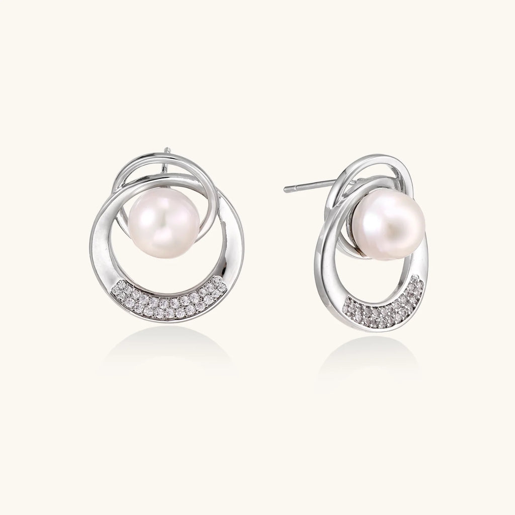 White gold-plated brass earrings with circular design, freshwater pearl center, and diamond accents