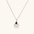 Gold necklace with navy lapis lazuli stone and iridescent mother-of-pearl teardrop pendant with crystal accents