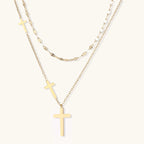 Three-layered gold necklace set with graduated cross pendants in mixed chain styles on white background.